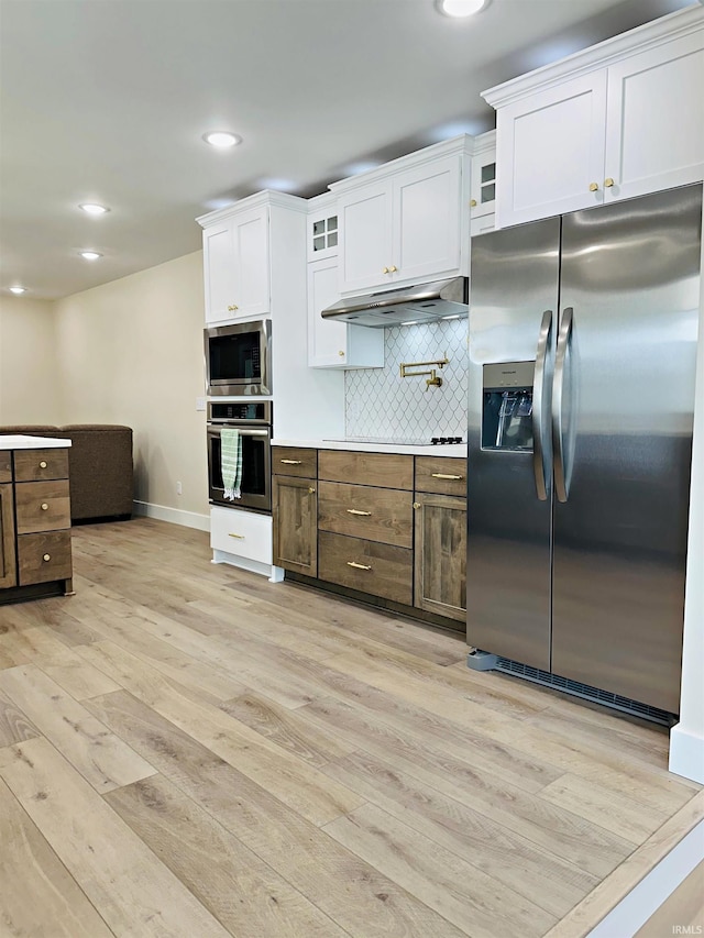 1412 E National Hwy, Washington, IN 47501 - kitchen featuring appliances with stainless steel finishes, under cabinet range hood, light wood finished floors, baseboards, and white cabinets