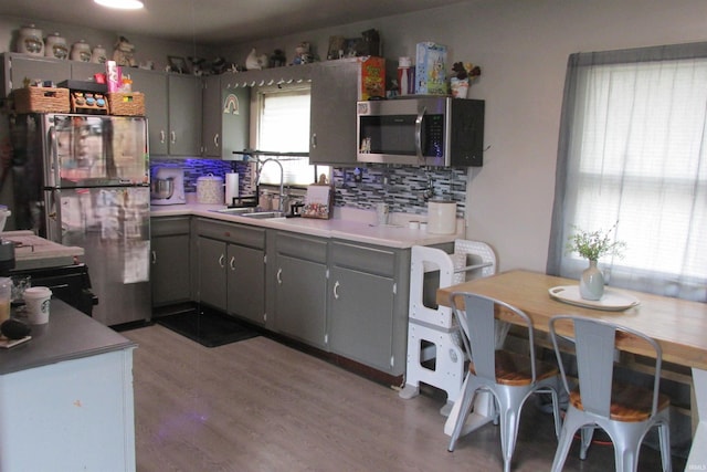 1908 E 18th St, Muncie, IN 47302 - kitchen with stainless steel appliances, a sink, backsplash, light wood-style floors, and light countertops
