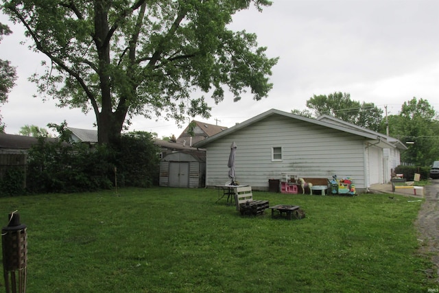1908 E 18th St, Muncie, IN 47302 - rear view of house featuring a yard, a garage, and an outdoor fire pit