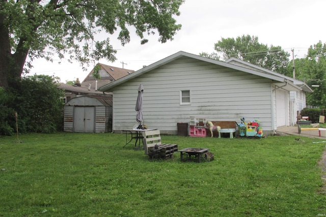1908 E 18th St, Muncie, IN 47302 - rear view of property featuring a lawn, a fire pit, and a garage