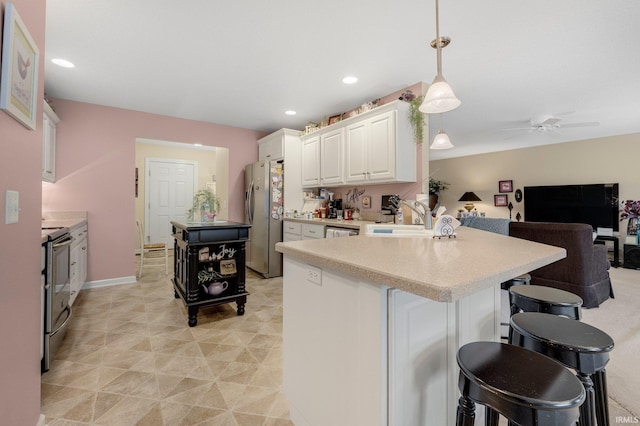 3441 Brantley Dr, New Haven, IN 46774 - kitchen featuring stainless steel appliances, a kitchen breakfast bar, a ceiling fan, a peninsula, and light countertops