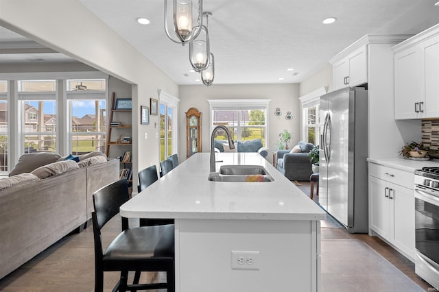 1159 Chesapeake Pointe Dr, Lafayette, IN 47909 - kitchen with stainless steel appliances, open floor plan, a sink, a breakfast bar, and recessed lighting