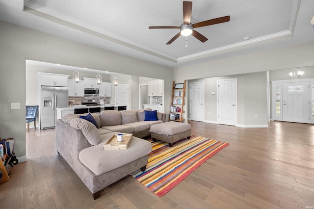 1159 Chesapeake Pointe Dr, Lafayette, IN 47909 - living room featuring a tray ceiling, ceiling fan, light wood-type flooring, and baseboards