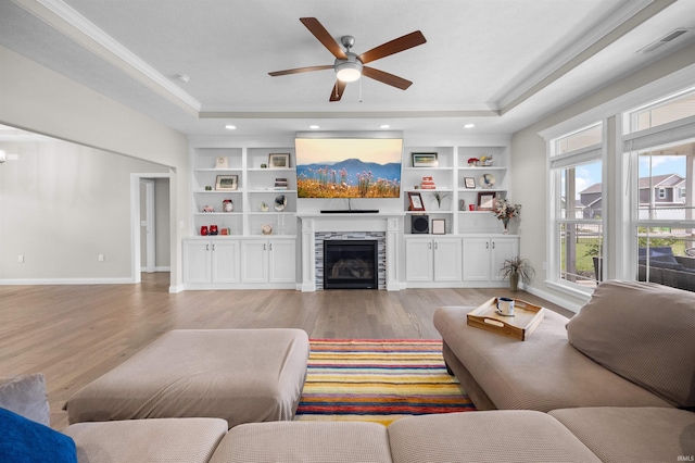 1159 Chesapeake Pointe Dr, Lafayette, IN 47909 - living room featuring a raised ceiling, light wood finished floors, built in features, crown molding, and recessed lighting
