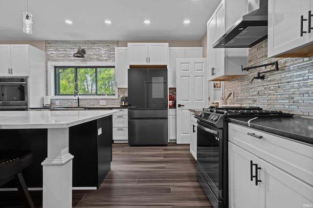 30474 Jaxon Dr, Elkhart, IN 46517 - kitchen featuring appliances with stainless steel finishes, wall chimney range hood, tasteful backsplash, recessed lighting, and white cabinets