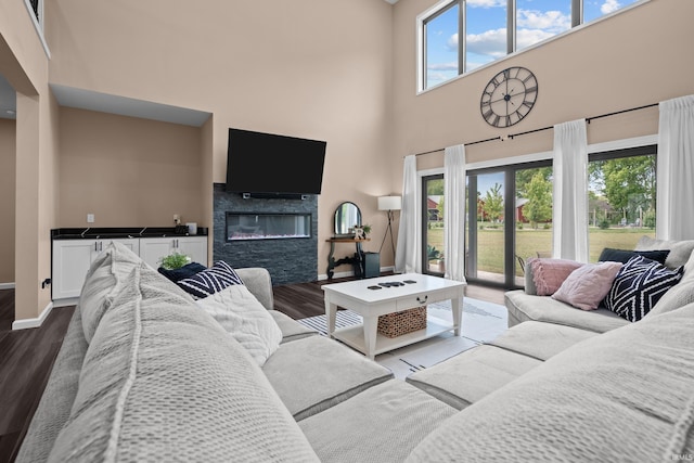 30474 Jaxon Dr, Elkhart, IN 46517 - living area featuring dark wood-style flooring, a high ceiling, plenty of natural light, baseboards, and a glass covered fireplace