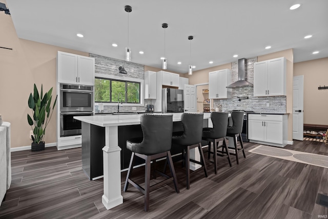 30474 Jaxon Dr, Elkhart, IN 46517 - kitchen with wall chimney exhaust hood, appliances with stainless steel finishes, backsplash, white cabinets, and a center island