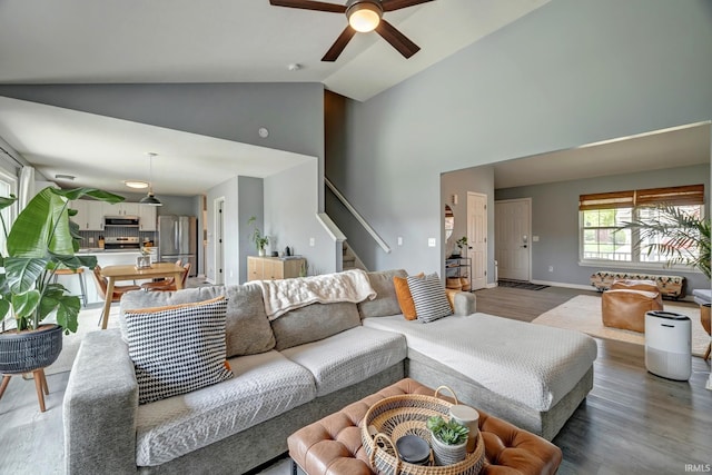 3063 N Natasha Dr, Bloomington, IN 47404 - living area featuring high vaulted ceiling, wood finished floors, stairs, a ceiling fan, and baseboards