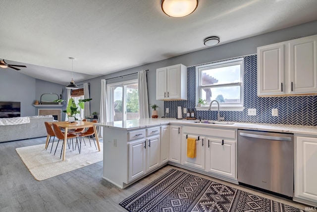 3063 N Natasha Dr, Bloomington, IN 47404 - kitchen featuring stainless steel dishwasher, a sink, backsplash, light wood-style floors, and lofted ceiling