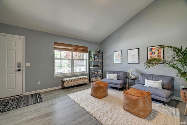 3063 N Natasha Dr, Bloomington, IN 47404 - living room with wood finished floors, baseboards, and high vaulted ceiling