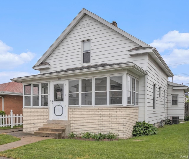715 W 7th St, Mishawaka, IN 46544 - view of front of property with entry steps, brick siding, a chimney, central air condition unit, and a sunroom