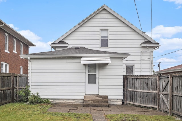 715 W 7th St, Mishawaka, IN 46544 - rear view of house with entry steps, a fenced backyard, and a shingled roof