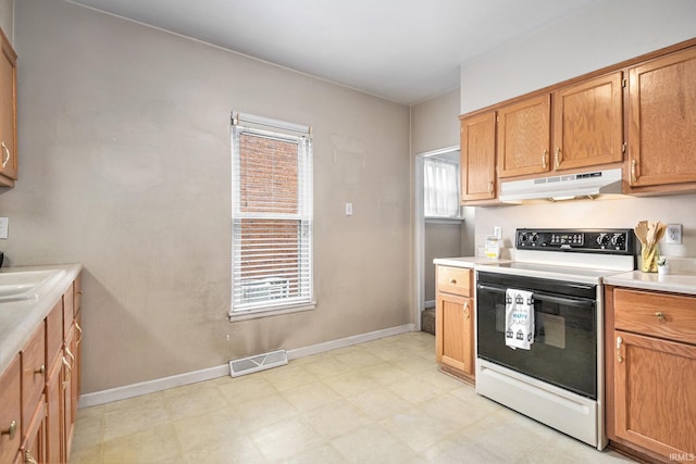 715 W 7th St, Mishawaka, IN 46544 - kitchen featuring electric stove, under cabinet range hood, light countertops, light flooring, and baseboards