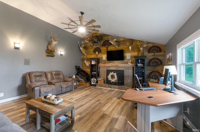 914 W 300 S, Bluffton, IN 46714 - living room featuring ceiling fan, a tiled fireplace, vaulted ceiling, wood finished floors, and baseboards