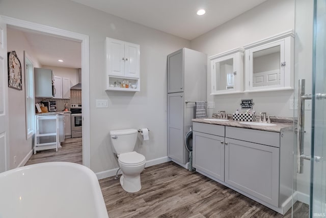 21 Noble St, Wabash, IN 46992 - bathroom featuring wood finished floors, toilet, vanity, decorative backsplash, and baseboards