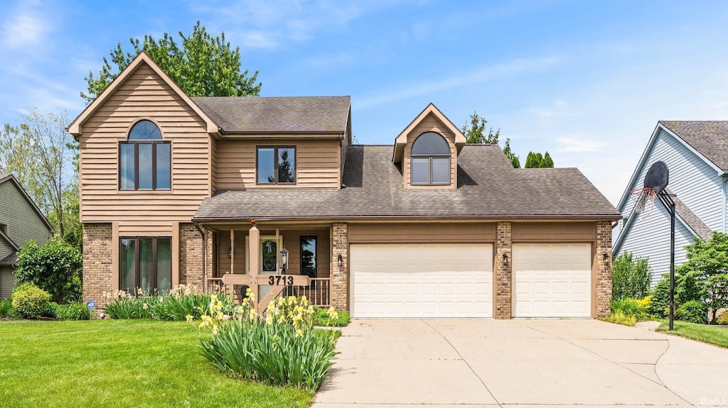 3713 Well Meadow Pl, Fort Wayne, IN 46815 - view of front facade with brick siding, a porch, driveway, a garage, and a front yard