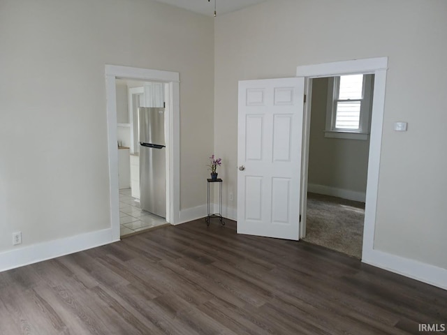 1237 E Illinois St, Evansville, IN 47711 - unfurnished bedroom with freestanding refrigerator, dark wood-style floors, baseboards, and ensuite bathroom