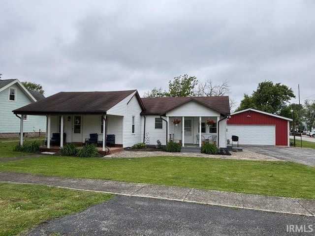 420 N New York St, Remington, IN 47977 - view of front of home featuring covered porch, an outdoor structure, a garage, and a front lawn