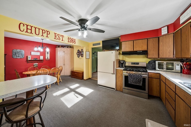 18377 Dunn Rd, South Bend, IN 46637 - kitchen featuring freestanding refrigerator, stainless steel gas range, under cabinet range hood, brown cabinetry, and light countertops