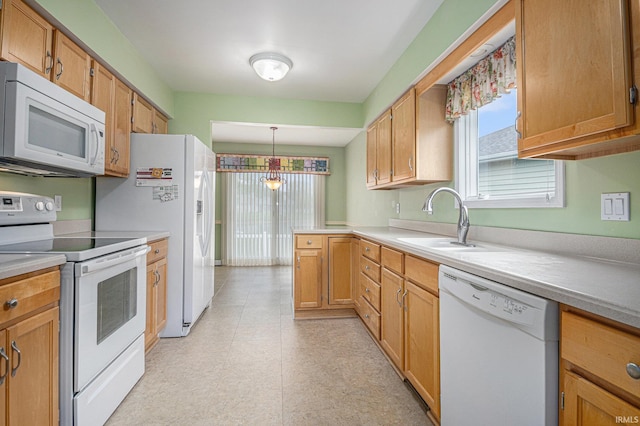 18586 Pauls Way S, Bend, IN 46637 - kitchen with white appliances, a sink, light countertops, hanging light fixtures, and a peninsula