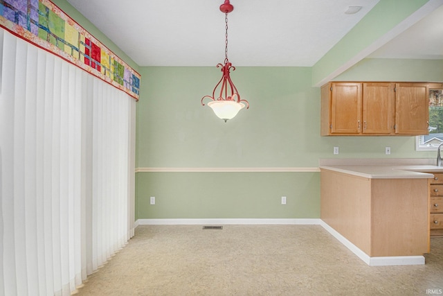 18586 Pauls Way S, Bend, IN 46637 - kitchen featuring light countertops, baseboards, decorative light fixtures, and light colored carpet