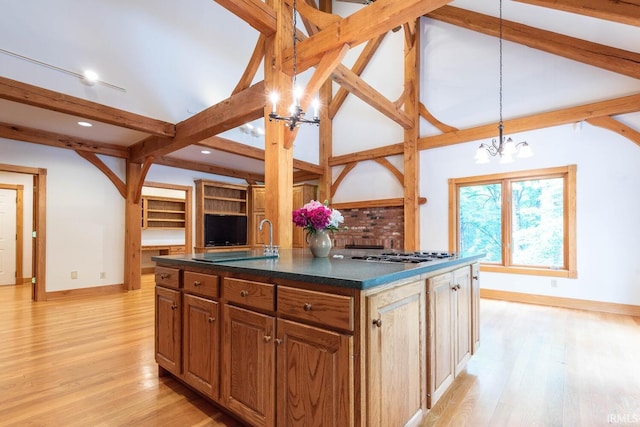 2557 S Smith Rd, Bloomington, IN 47401 - kitchen with baseboards, a chandelier, light wood-style floors, stainless steel gas cooktop, and pendant lighting