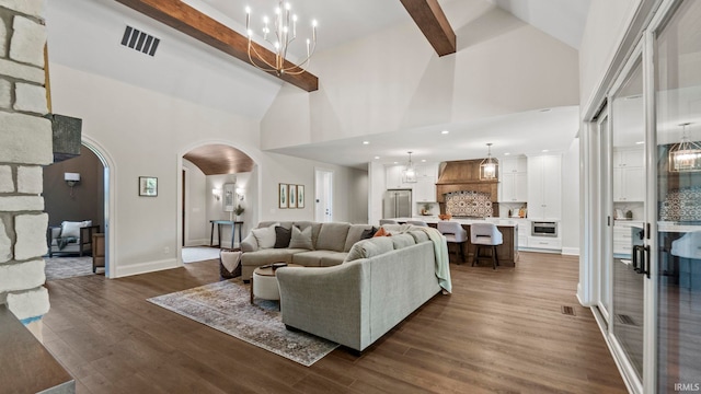 447 E Basalt Dr, Huntertown, IN 46748 - living room with arched walkways, dark wood finished floors, high vaulted ceiling, baseboards, and a chandelier