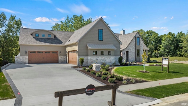447 E Basalt Dr, Huntertown, IN 46748 - view of front of home featuring stone siding, a front yard, driveway, an attached garage, and a shingled roof