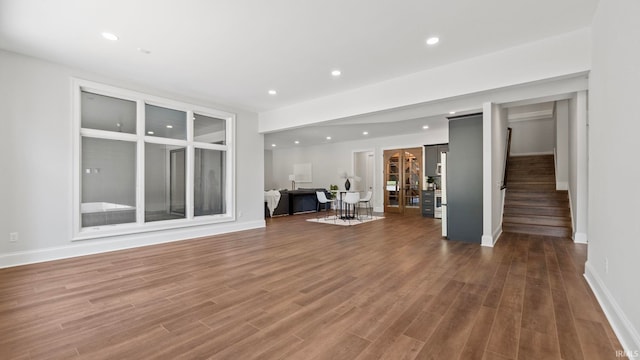 447 E Basalt Dr, Huntertown, IN 46748 - unfurnished living room featuring baseboards, wood finished floors, stairs, and recessed lighting