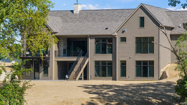 447 E Basalt Dr, Huntertown, IN 46748 - rear view of property featuring a chimney, stairs, and roof with shingles