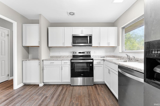 1024 Tulip Tree Rd, Fort Wayne, IN 46825 - kitchen with stainless steel appliances, a sink, white cabinetry, dark wood-style floors, and light countertops