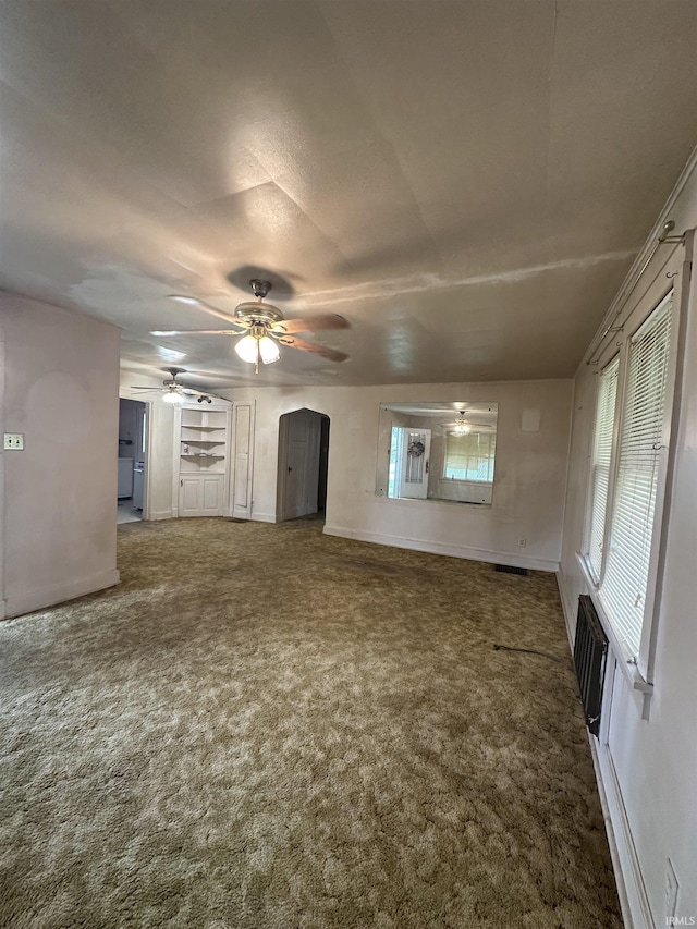 539 NE 9th St, Linton, IN 47441 - unfurnished living room with a ceiling fan, carpet flooring, baseboards, and arched walkways