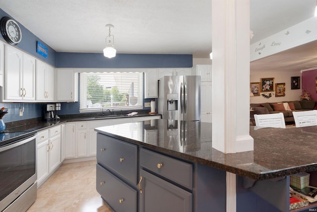 404 S Maple St, Greentown, IN 46936 - kitchen with stainless steel appliances, a sink, white cabinets, dark stone counters, and open floor plan