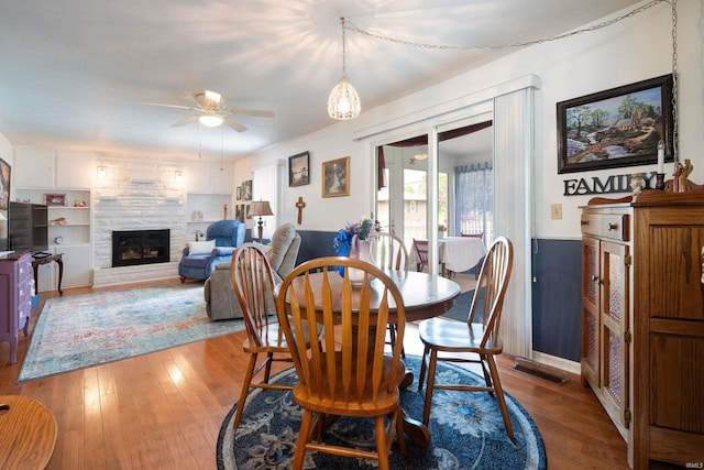 404 S Maple St, Greentown, IN 46936 - dining area with a ceiling fan, hardwood / wood-style flooring, and a stone fireplace