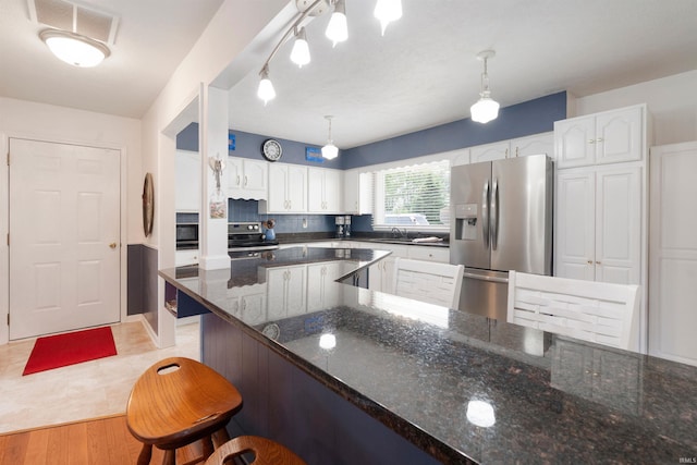 404 S Maple St, Greentown, IN 46936 - kitchen with appliances with stainless steel finishes, white cabinets, dark stone countertops, and a breakfast bar