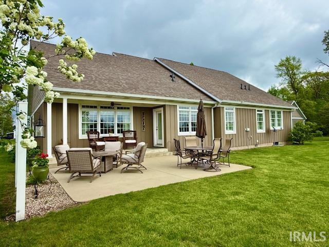 4968 W Campbell St, North Judson, IN 46366 - back of house with a lawn, a patio, board and batten siding, and a shingled roof