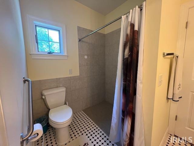 3638 N 1500 W Rd, Linton, IN 47441 - bathroom with a tile shower, toilet, tile walls, tile patterned flooring, and a wainscoted wall