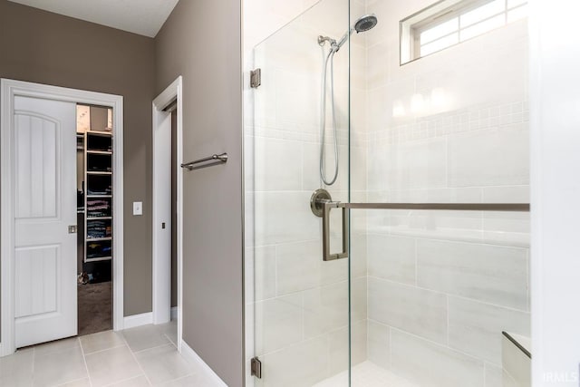 12475 Speranza Dr, Fort Wayne, IN 46818 - bathroom featuring a stall shower, tile patterned floors, a walk in closet, and baseboards