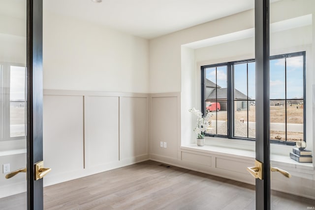 12318 Rain Lily Ct, Fort Wayne, IN 46814 - unfurnished room featuring a decorative wall, wood finished floors, and wainscoting