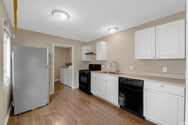 1510 W 4th St, Fort Wayne, IN 46808 - kitchen featuring black appliances, a sink, separate washer and dryer, light wood-type flooring, and baseboards