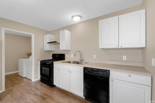 1510 W 4th St, Fort Wayne, IN 46808 - kitchen with black appliances, a sink, washing machine and clothes dryer, light wood-style flooring, and white cabinets