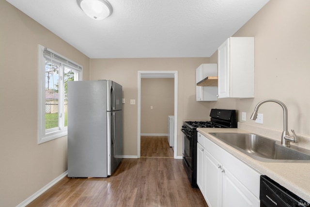 1510 W 4th St, Fort Wayne, IN 46808 - kitchen featuring black appliances, wood finished floors, a sink, baseboards, and white cabinetry