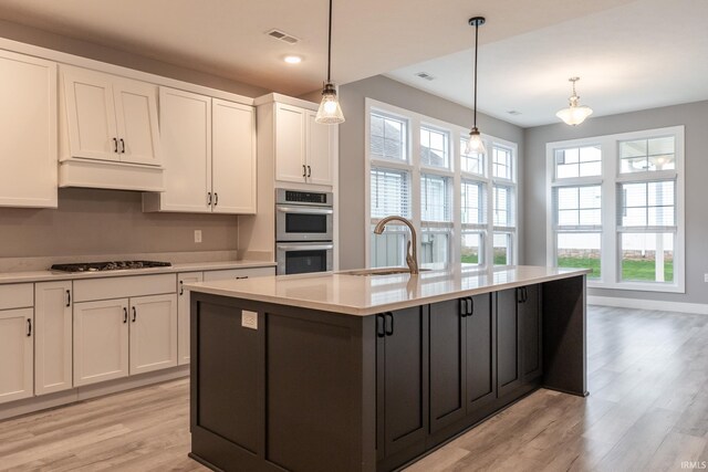 1590 S Renwick Blvd, Bloomington, IN 47401 - kitchen with a sink, double oven, light wood-style floors, white cabinets, and recessed lighting