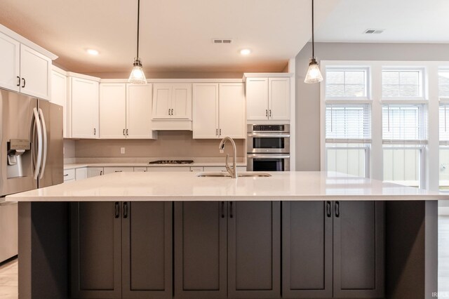 1590 S Renwick Blvd, Bloomington, IN 47401 - kitchen featuring stainless steel appliances, white cabinets, a sink, light countertops, and recessed lighting