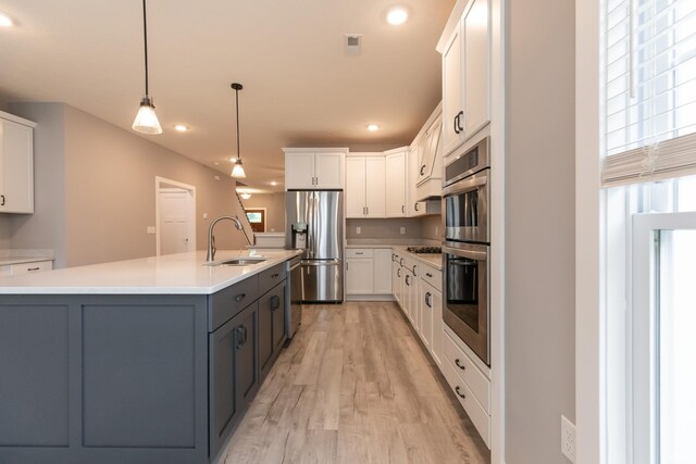 1590 S Renwick Blvd, Bloomington, IN 47401 - kitchen with a sink, appliances with stainless steel finishes, light wood-style flooring, white cabinetry, and recessed lighting