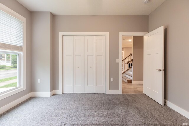 1590 S Renwick Blvd, Bloomington, IN 47401 - unfurnished bedroom featuring light carpet, a closet, and baseboards