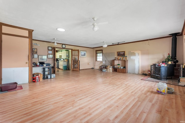 5668 E 500 S, Lynn, IN 47355 - living area featuring a wood stove, a ceiling fan, ornamental molding, and wood finished floors
