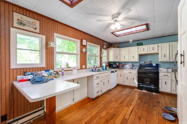 5668 E 500 S, Lynn, IN 47355 - kitchen with black appliances, a skylight, a peninsula, white cabinets, and a baseboard heating unit