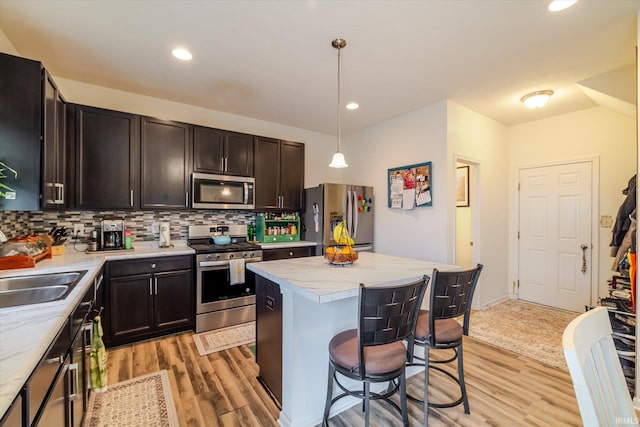 4671 W Hidden Meadow Dr, Bloomington, IN 47404 - kitchen with appliances with stainless steel finishes, light wood finished floors, tasteful backsplash, a kitchen breakfast bar, and dark brown cabinets