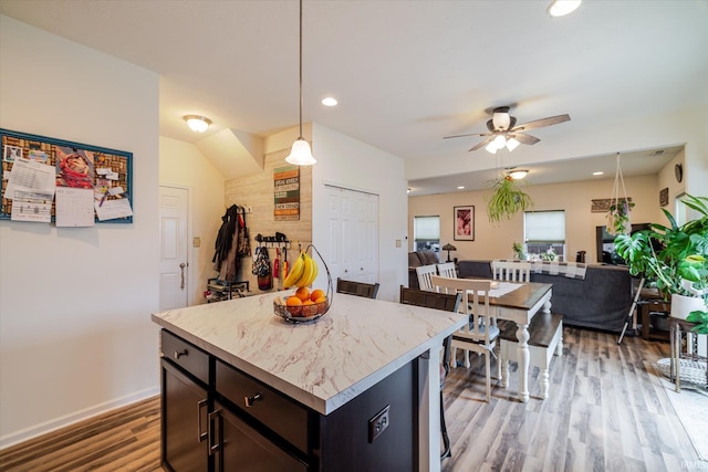4671 W Hidden Meadow Dr, Bloomington, IN 47404 - kitchen featuring light wood-style flooring, open floor plan, ceiling fan, pendant lighting, and a kitchen island